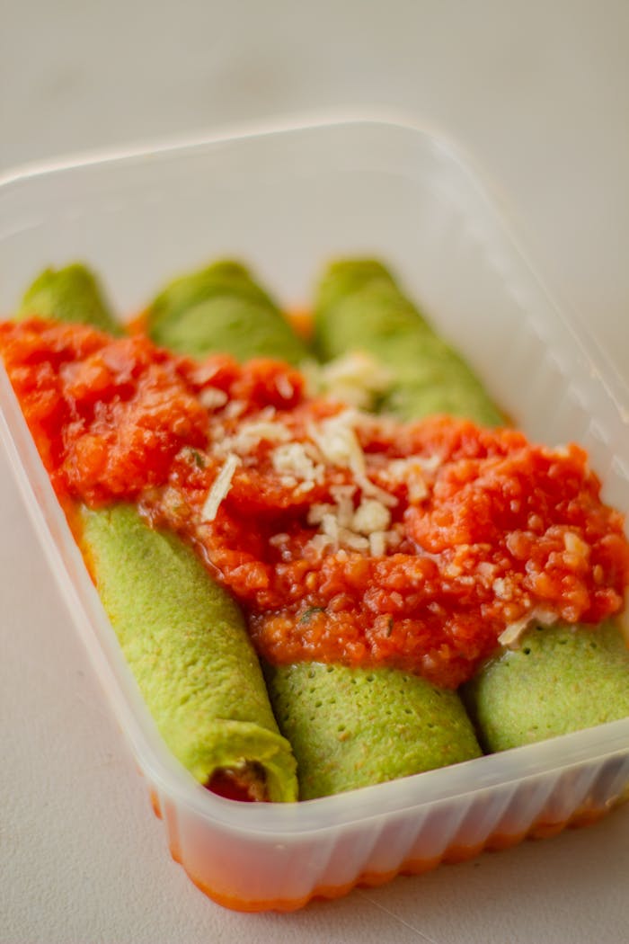 Tasty spinach crepes topped with fresh tomato sauce, perfect for a healthy meal.
